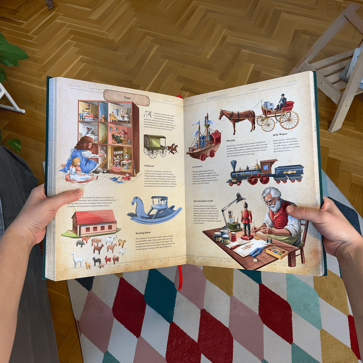 Hands holding an open copy of The Codex featuring detailed illustrations of vintage toys and a toy artisan.
