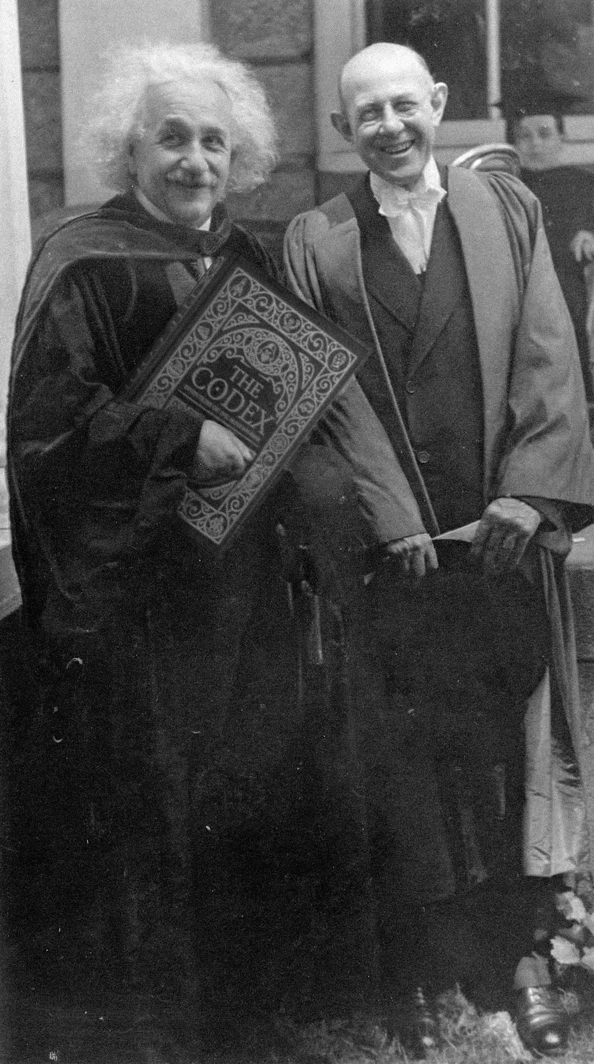 Black-and-white image of Albert Einstein holding The Codex: Inventions of the Human Mind illustrated book, connecting science history, invention, and great thinkers