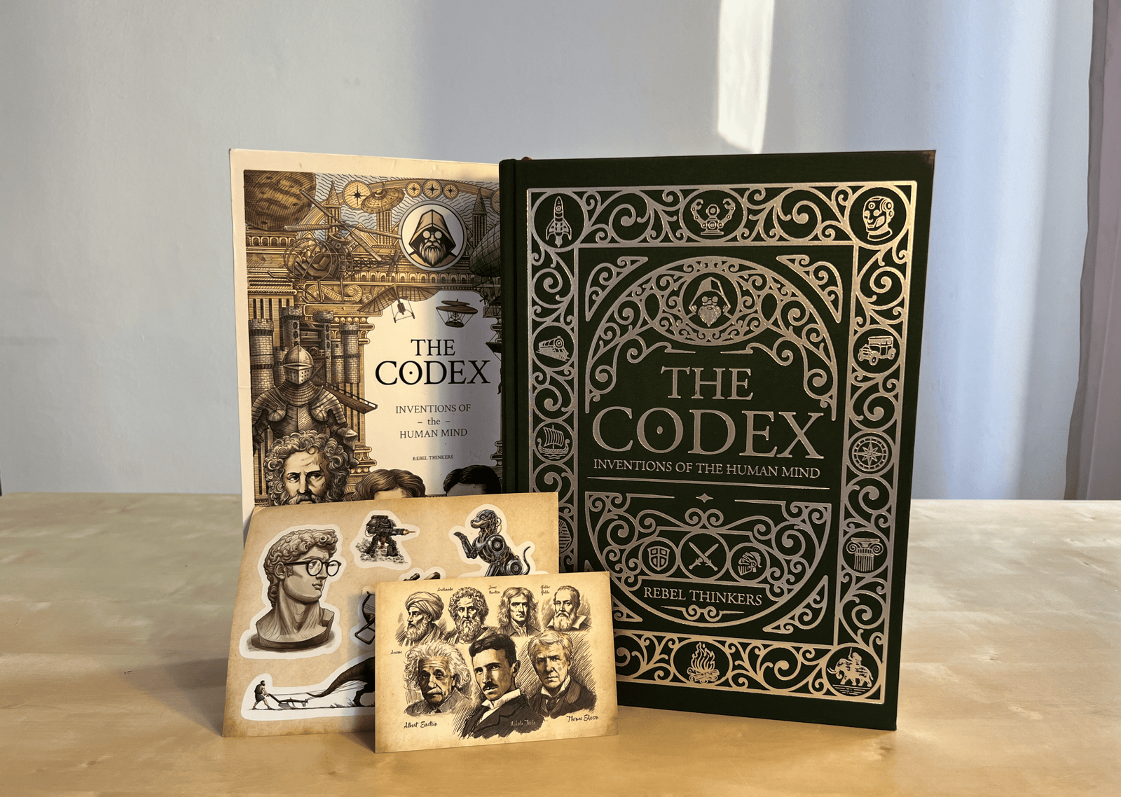 Green foil hardcover book edition of The Codex displayed with its illustrated slipcover and bonus collector inserts.