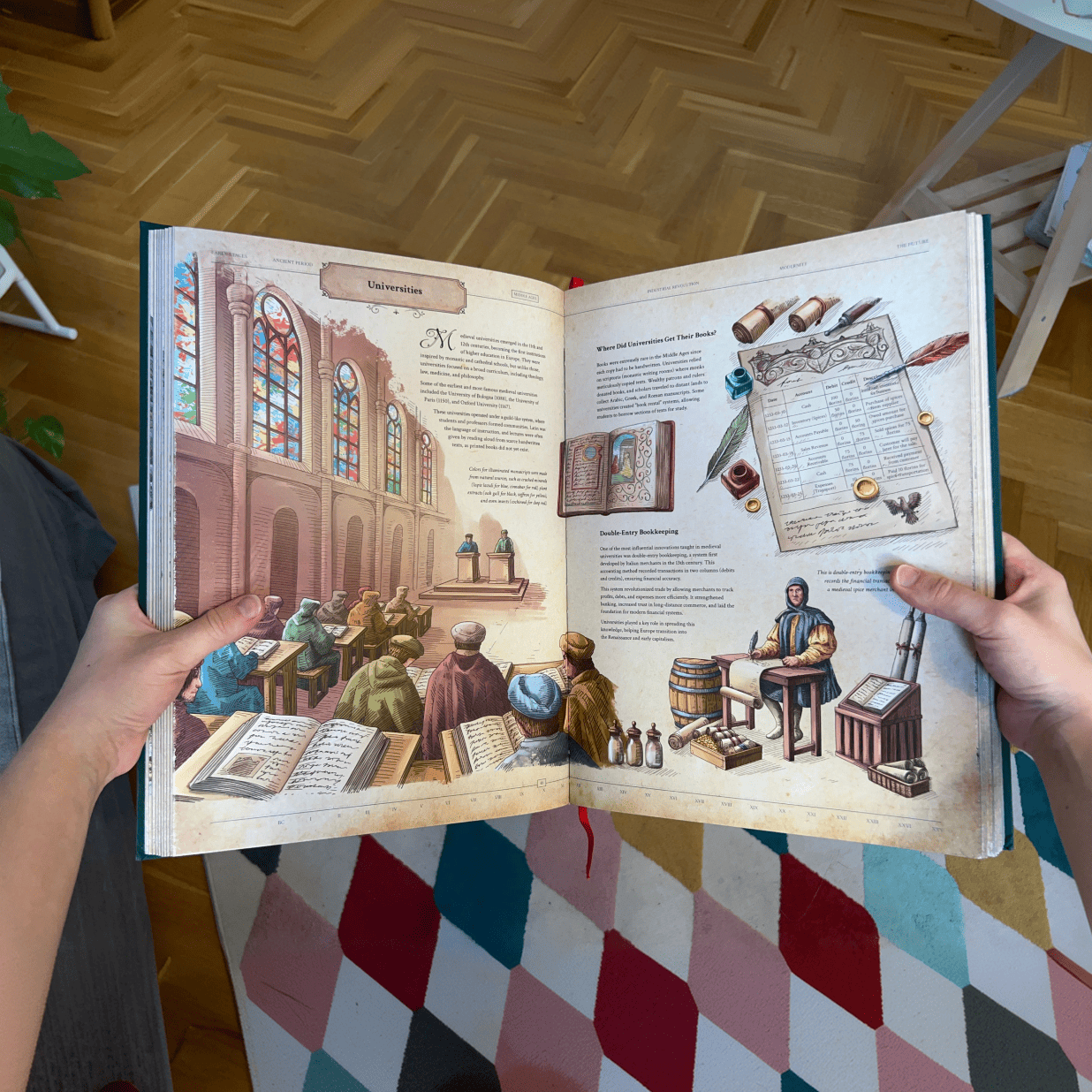 Hands holding open The Codex book to a spread featuring cathedral classroom illustrations and historical accounting ledger art.